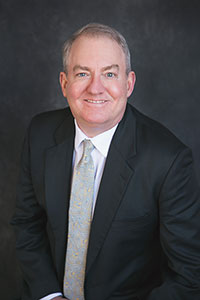 portrait photo of a smiling Dr. Coppersmith wearing a business suit