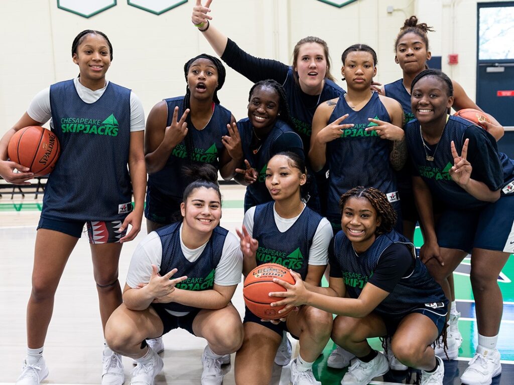 The members of the women's basketball team pose for an informal group photo with fun poses and smiles