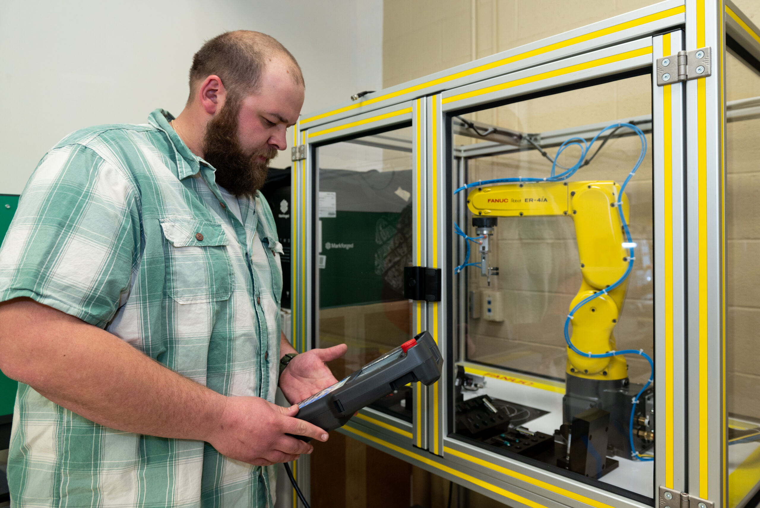 Student working with FANUC robot in Advanced Manufacturing course.