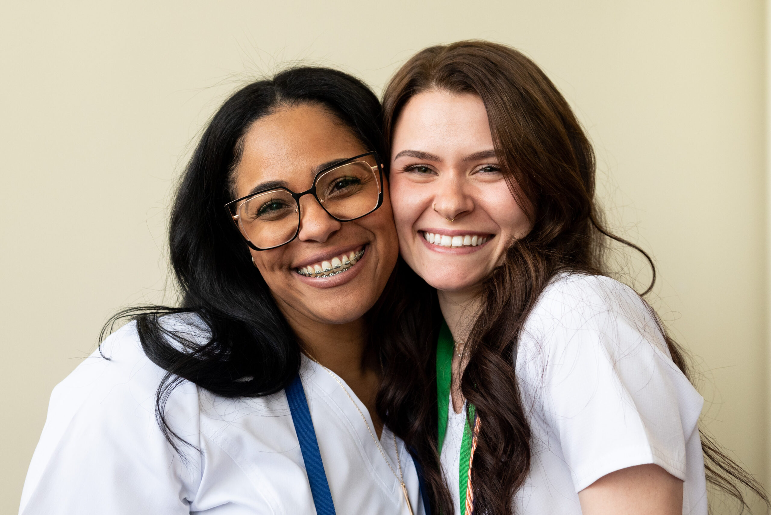 Two female nursing graduates smiling.