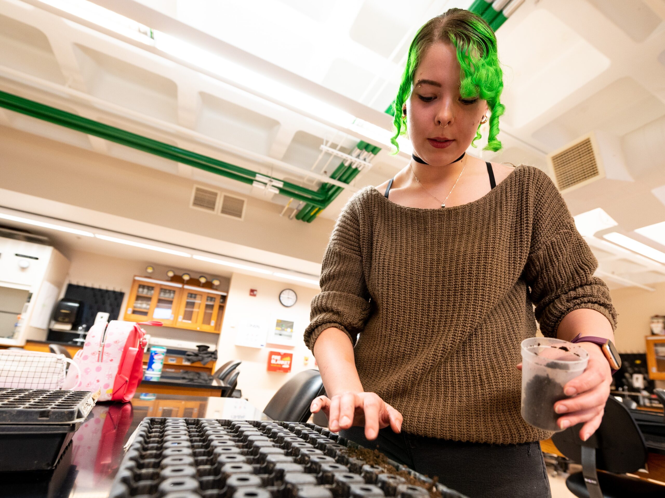 a student fills seed beds with potting soil