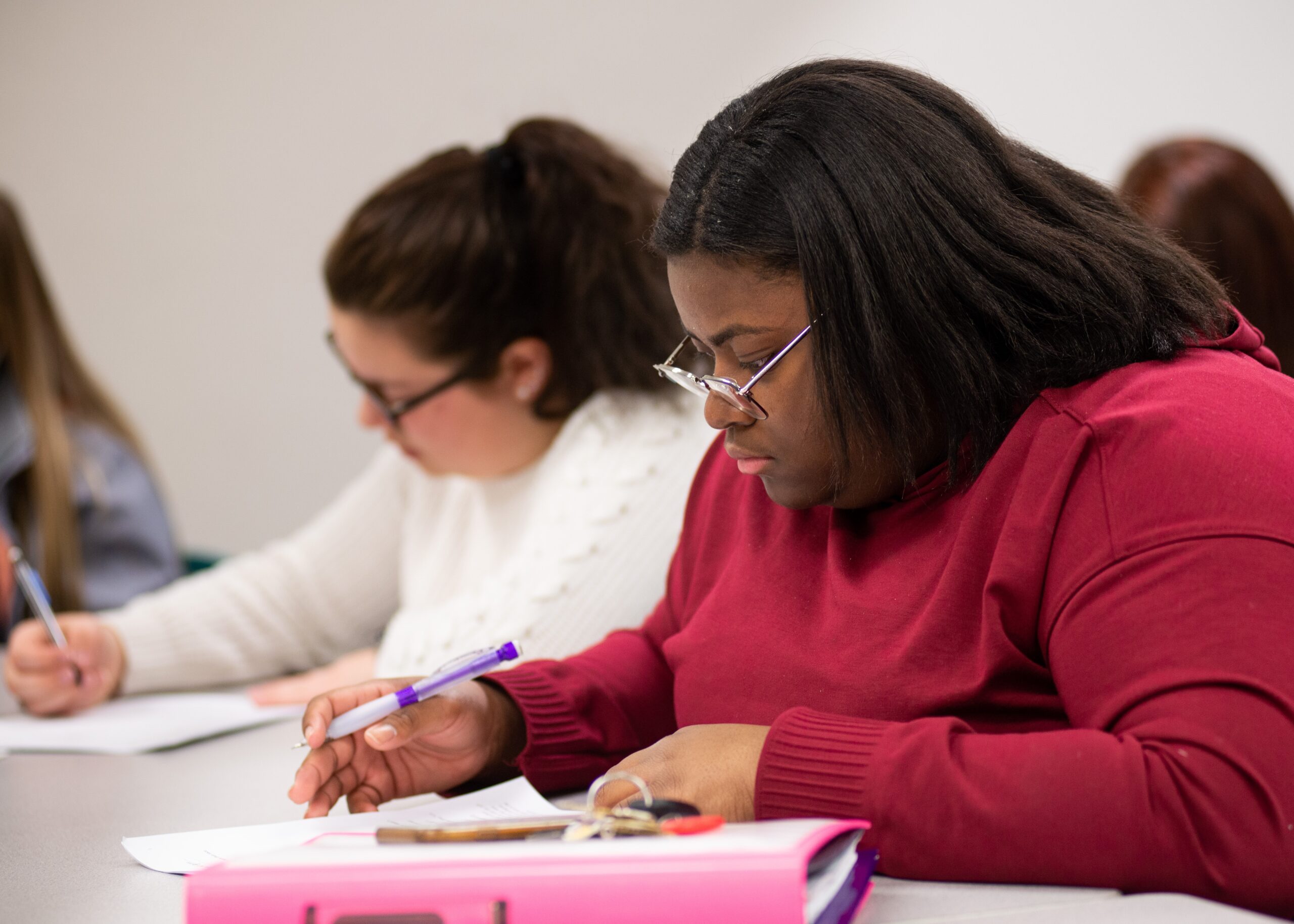 College students are engaged in thoughtful writing in a classroom.