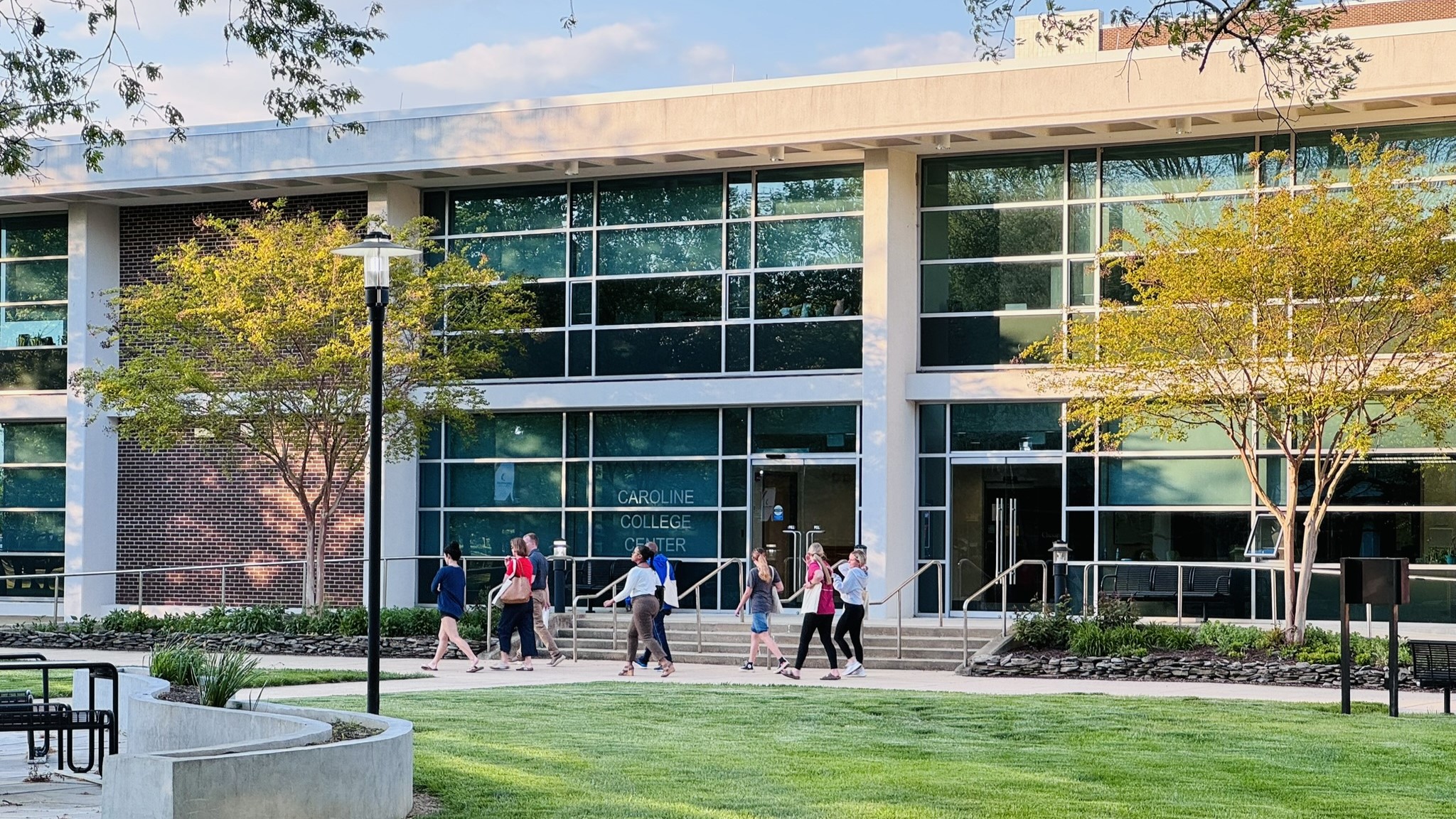 Families walk in front of Caroline Center while visiting campus in April