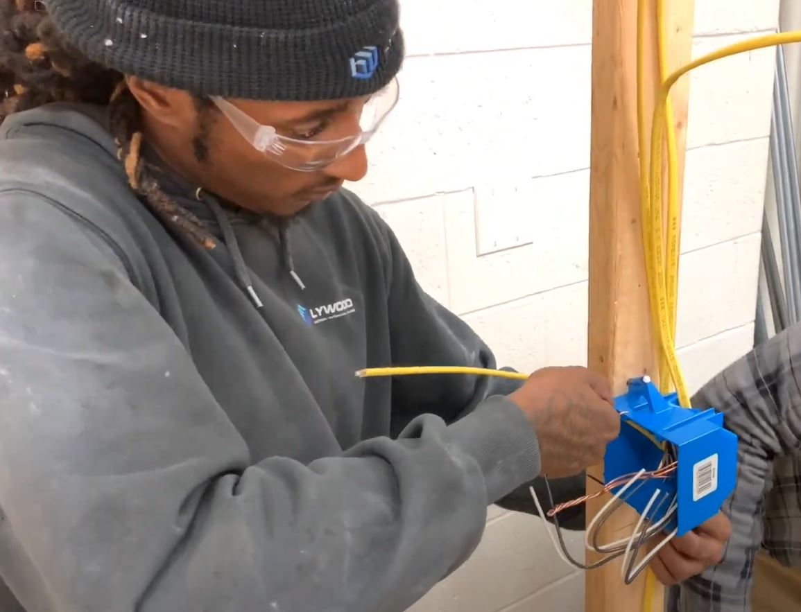 Electrical Technician student works on wiring an electrical unit.