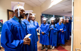 Adult Basic Ed graduates pose in caps and gowns, October 2024